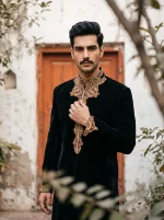 Men's royal black sherwani crafted from premium tropical fabric, featuring intricate handmade golden embroidery on the collar, front, and cuffs, perfect for weddings, grooms, and formal occasions.