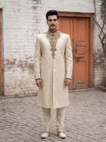 Royal Ivory Jamawar Sherwani featuring intricate handmade golden embroidery, elegant floral patterns, and a traditional mandarin collar, perfect for grooms, Nikah, Barat, and wedding celebrations.