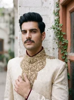 Royal Ivory Jamawar Sherwani featuring intricate handmade golden embroidery, elegant floral patterns, and a traditional mandarin collar, perfect for grooms, Nikah, Barat, and wedding celebrations.